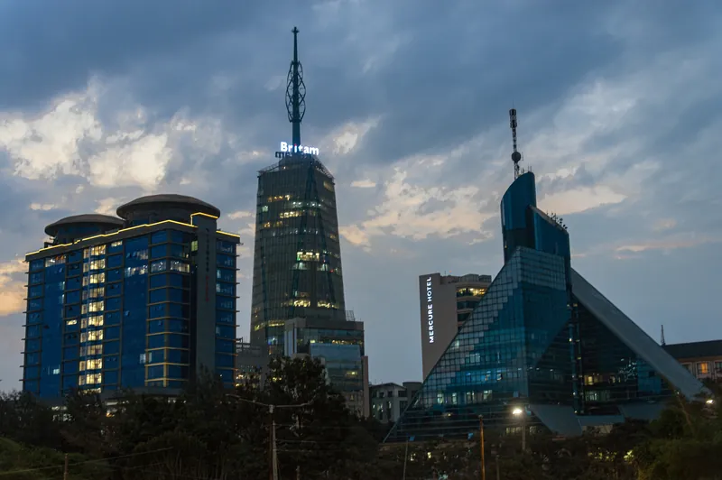 Nairobi skyline at blue hour: Britam Tower and Upper Hill towers lit up at dusk, seen on a private Nairobi layover tour from JKIA